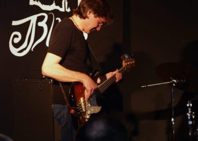 Marek Idzik grający na gitarze basowej.